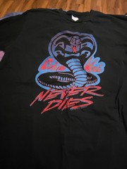 black t-shirt with a blue and red Cobra Kai logo and the text “Cobra Kai…