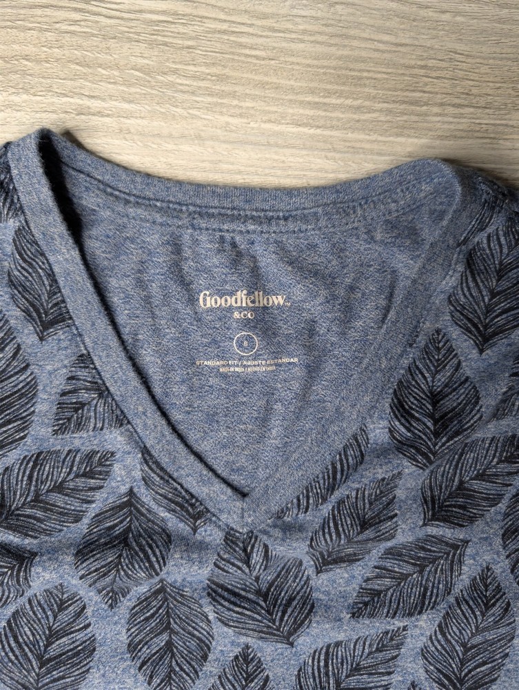 This blue Goodfellow & Co v-neck shirt features a dark leaf pattern.