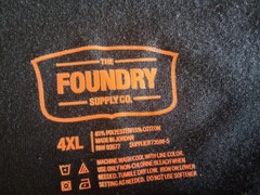 Men’s size 4XL black Tee w/ gray camouflage on front by Foundry. Excellent cond