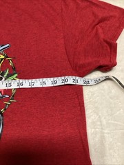 Guns And Roses Red Shirt With Skull Design Wearing A Blue And Black Hat.