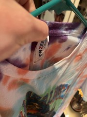 Lollapalooza 2025 multicolored tie dye shirt with list of the performers on back