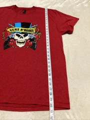 Guns And Roses Red Shirt With Skull Design Wearing A Blue And Black Hat.