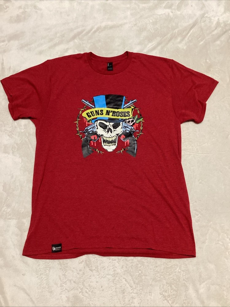 Guns And Roses Red Shirt With Skull Design Wearing A Blue And Black Hat.