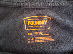 Men’s size 4XL black Tee w/ gray camouflage on front by Foundry. Excellent cond