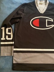 Champion #19 Champion Logo Hockey Jersey Sz L (44) (25in W X 30in L) Black
