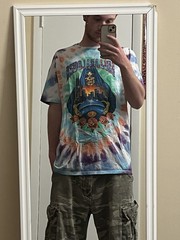 Lollapalooza 2025 multicolored tie dye shirt with list of the performers on back